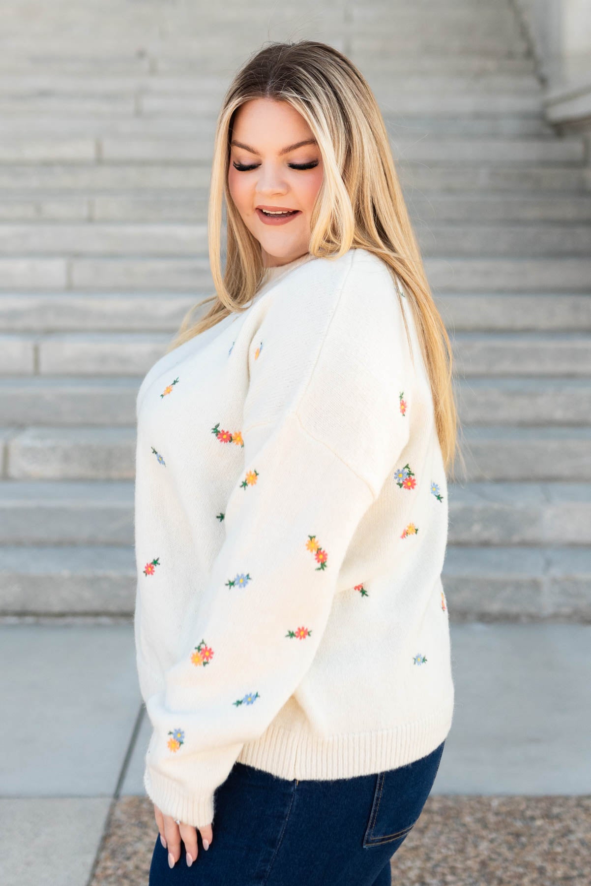 Side view of the plus size ivory floral embroidered sweater