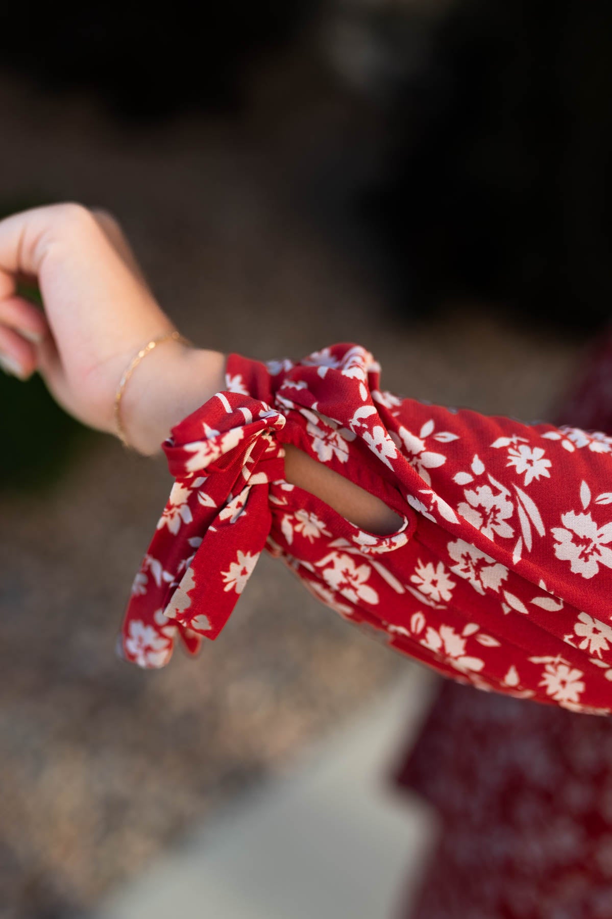 The ties on the cuff of a red floral dress