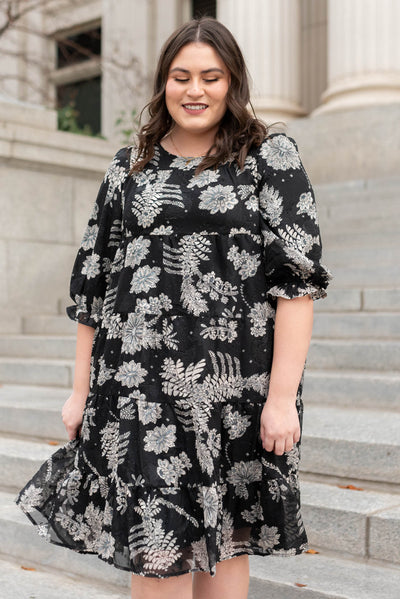 Front view of a black floral dress with tiered skirt