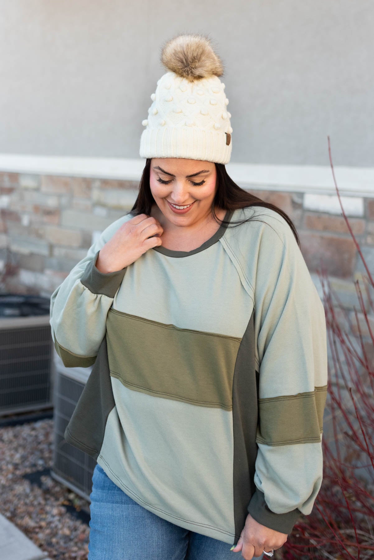 Front view of a long sleeve olive block sweater