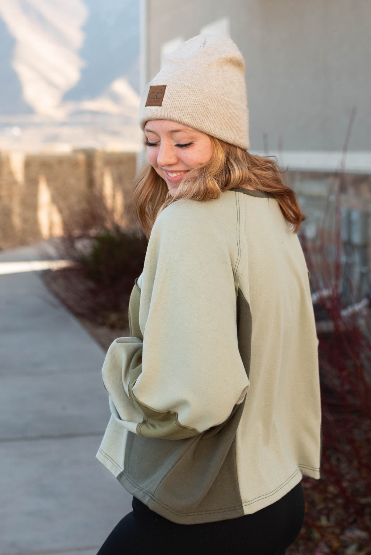 Side view of a olive block sweater