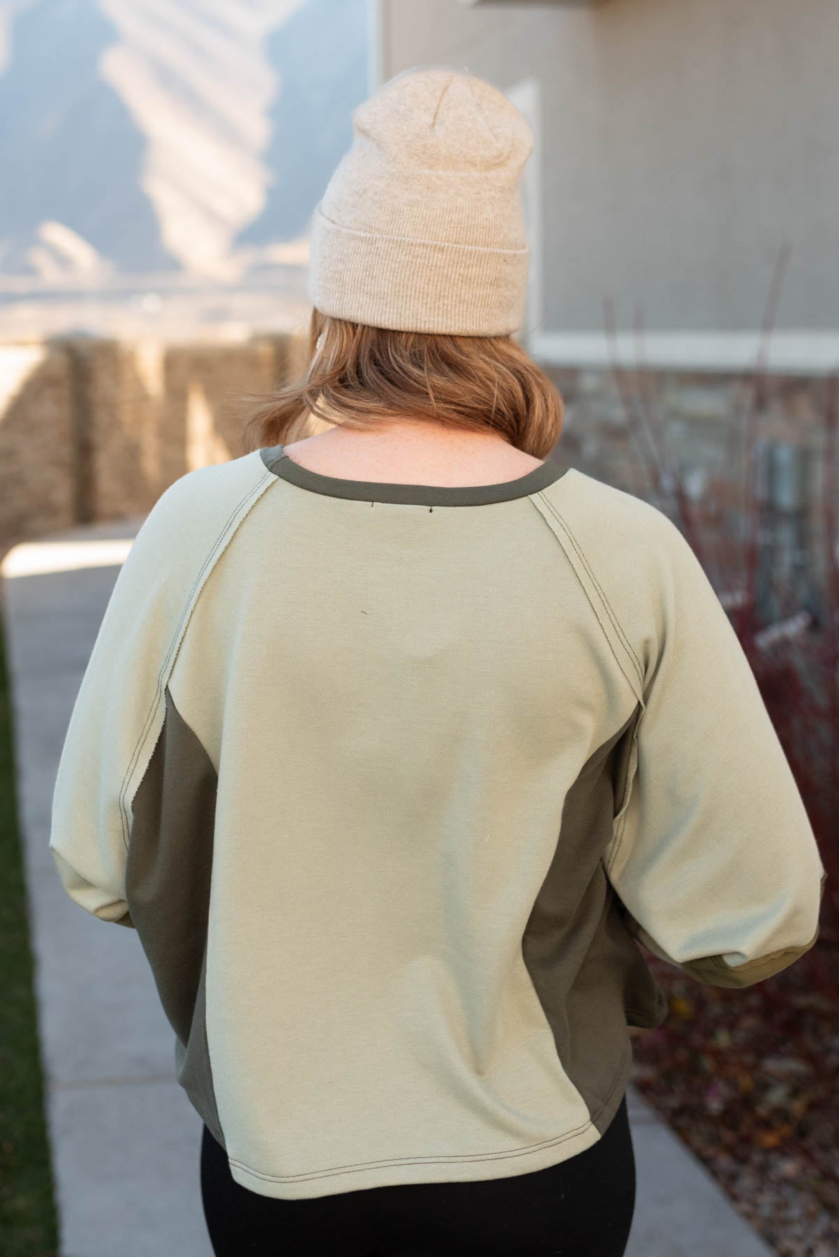 Back view of a olive block sweater