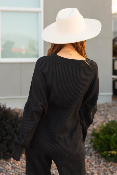 Back view of a long sleeve black sweater