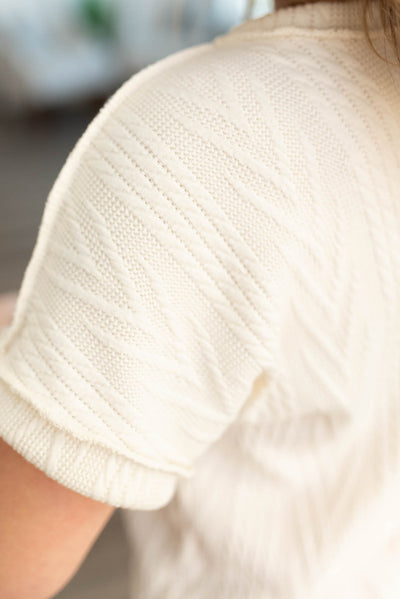 Close up of the textured fabric on an ivory top