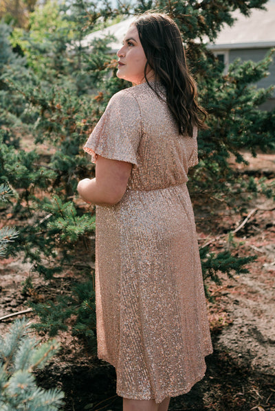 Side view of a plus size rose gold sequin dress
