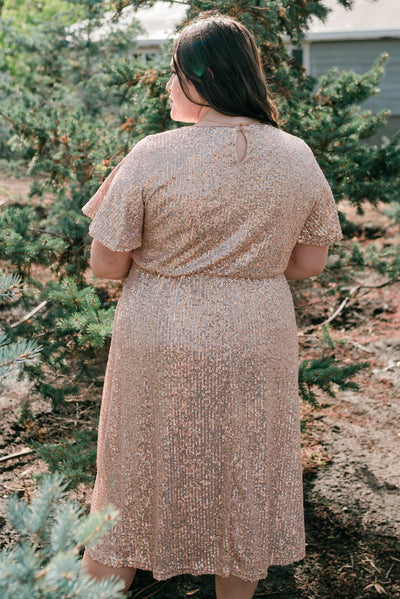 Back view of a plus size rose gold sequin dress