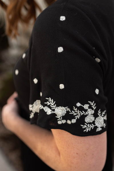 Embroidery detail on a black floral dress