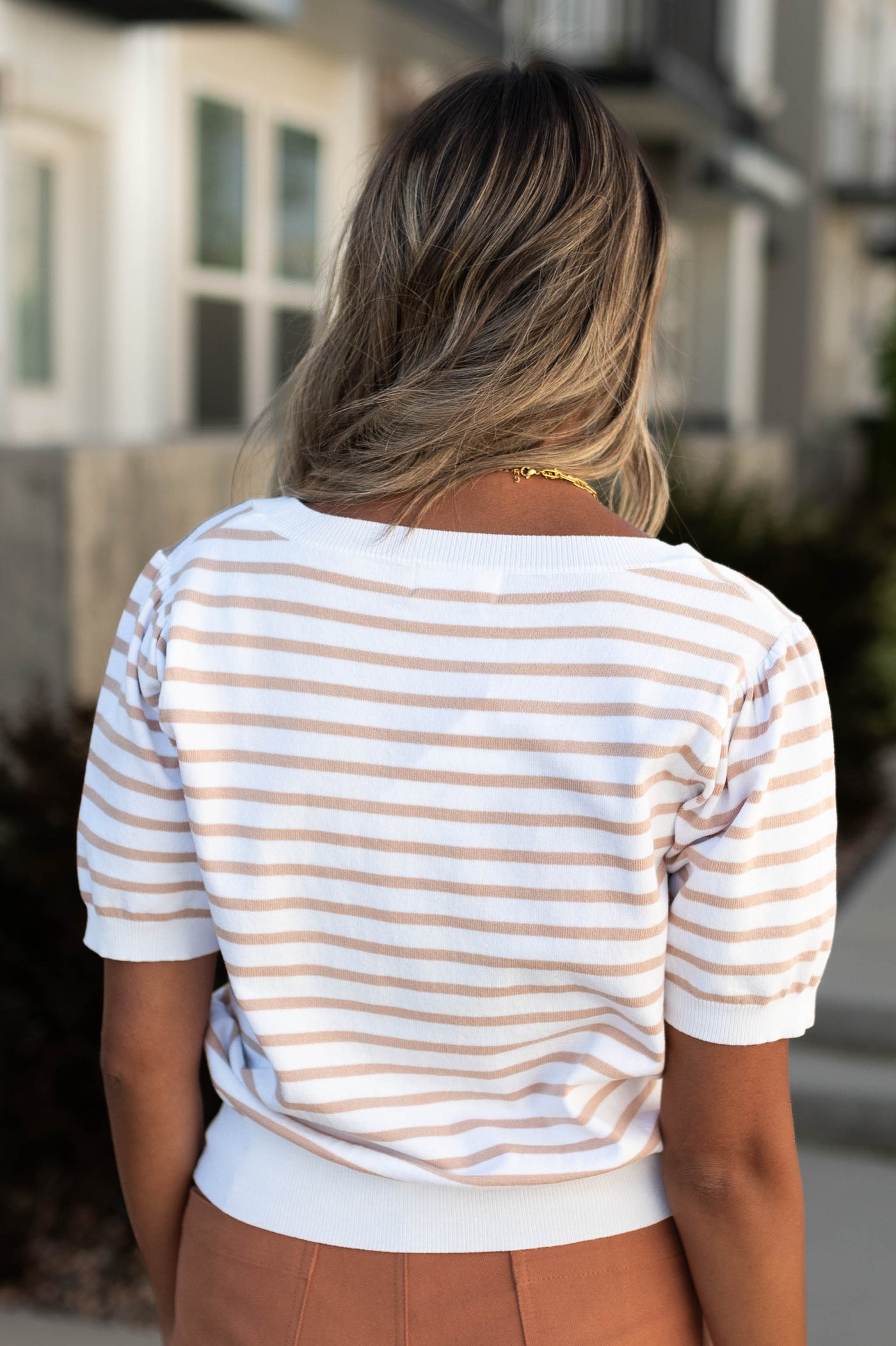 Back view of a taupe striped top
