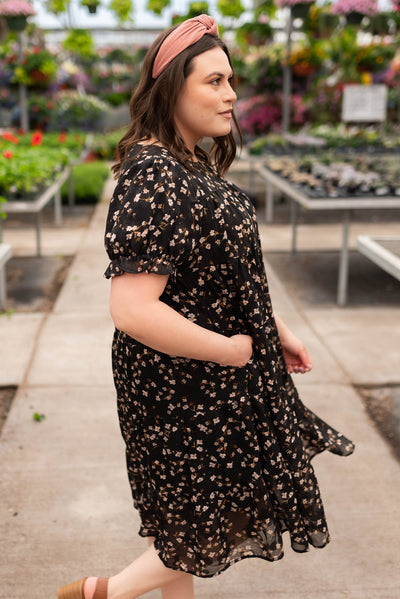 Side view of the plus size black floral midi dress with pockets
