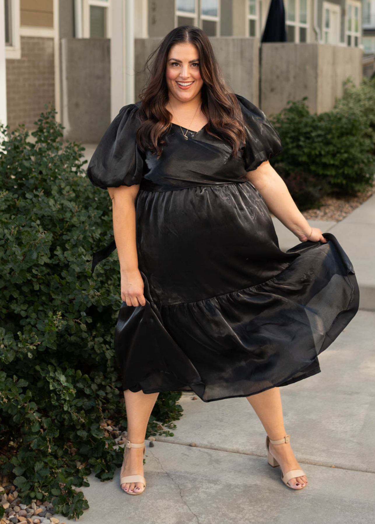 Plus size black dress with wrap style bodice and ruffle at the hem