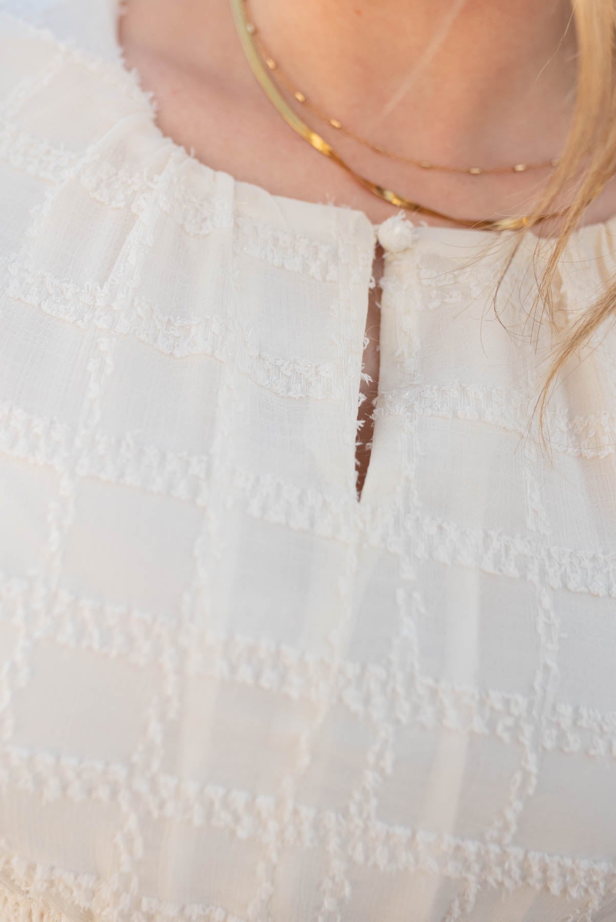 Neckline of a cream glitter maxi dress