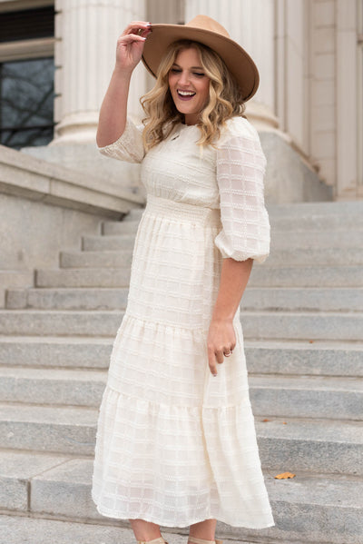 Side view of a cream glitter maxi dress