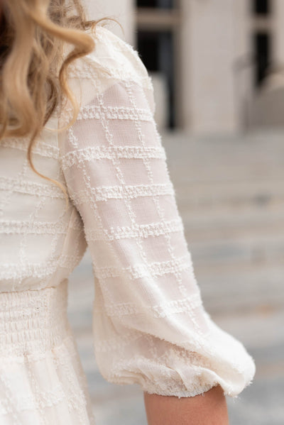 Fabric pattern on the sleeve of a cream glitter maxi dress