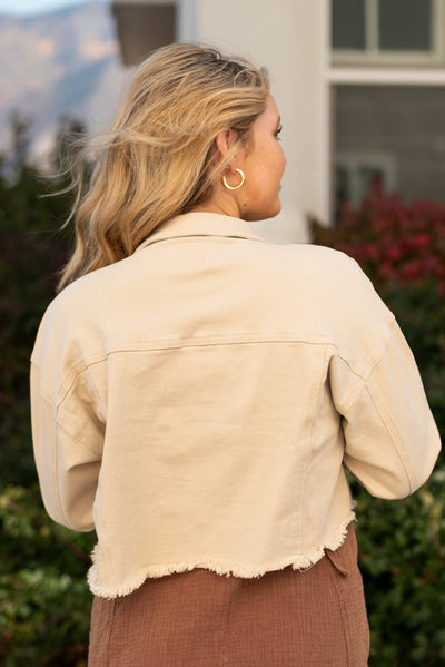 Back view of a beige button down jacket