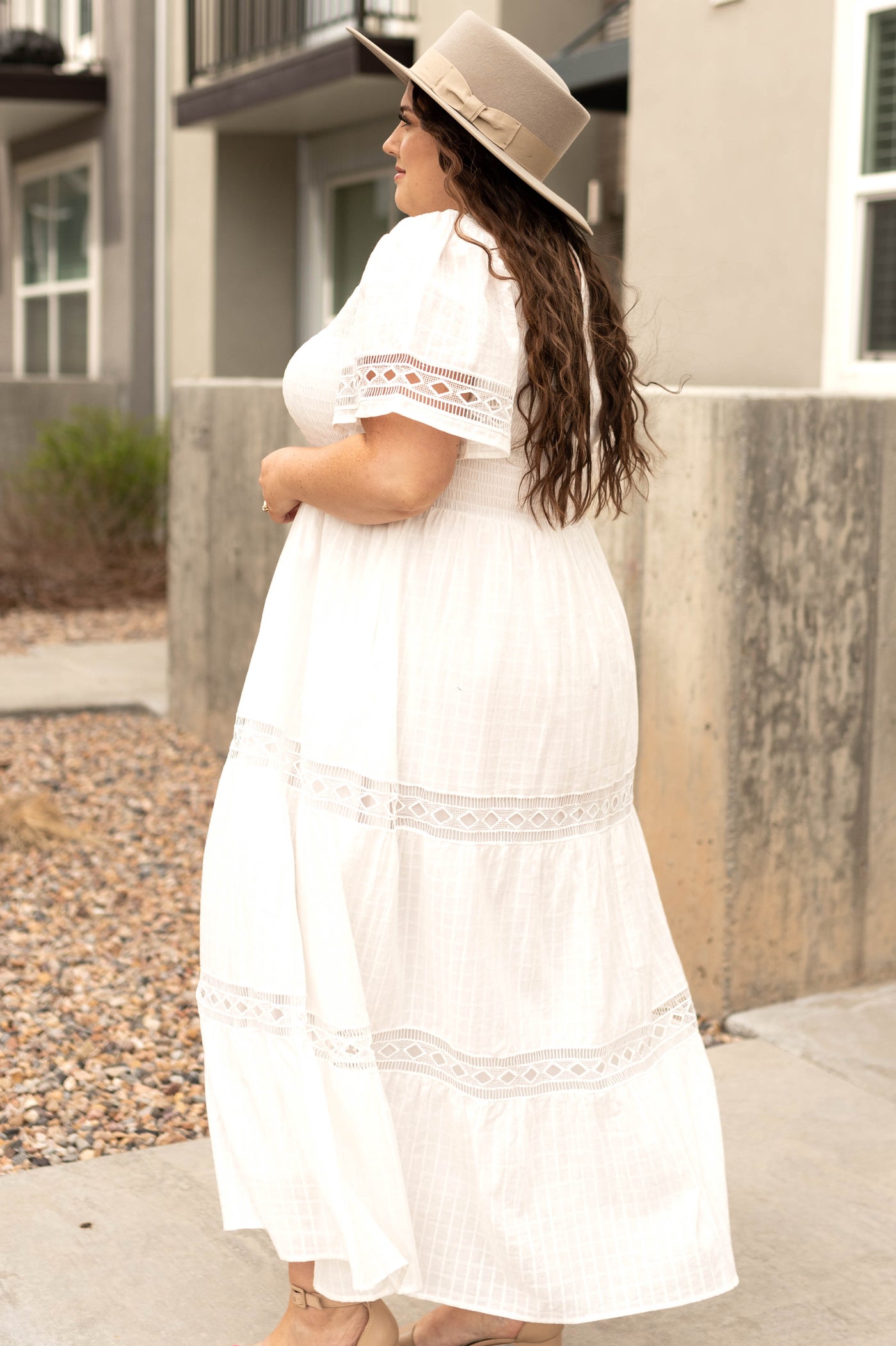 Side view of a plus size long white dress with lace detail