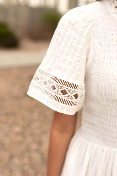 Sleeve view of white dress and it lace