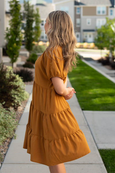 Side view of a deep spice dress with tiered skirt