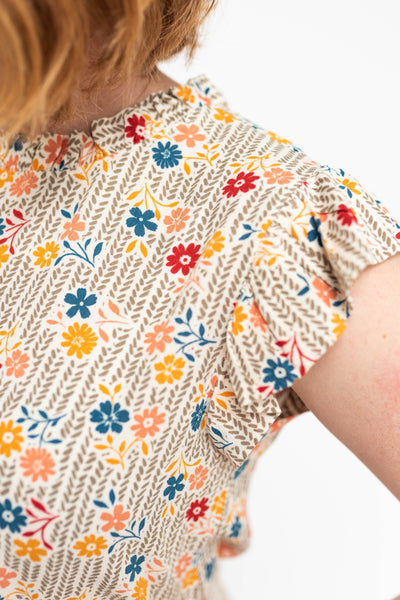 Sleeve view of a taupe floral top