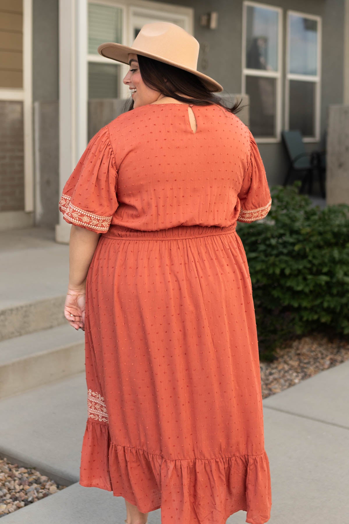 Back view of a plus size rust dress
