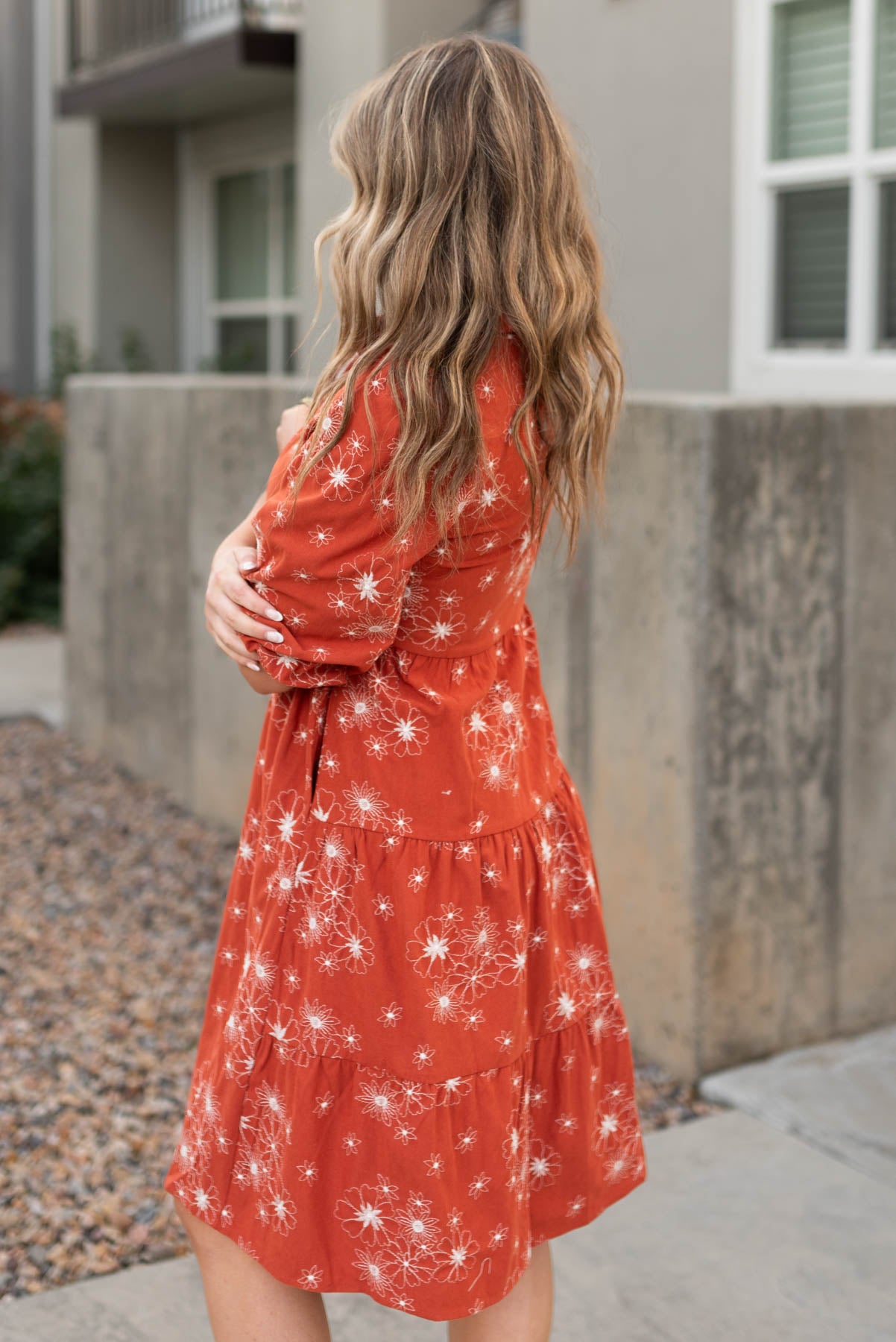 Side view of a rust corduroy embroidered dress