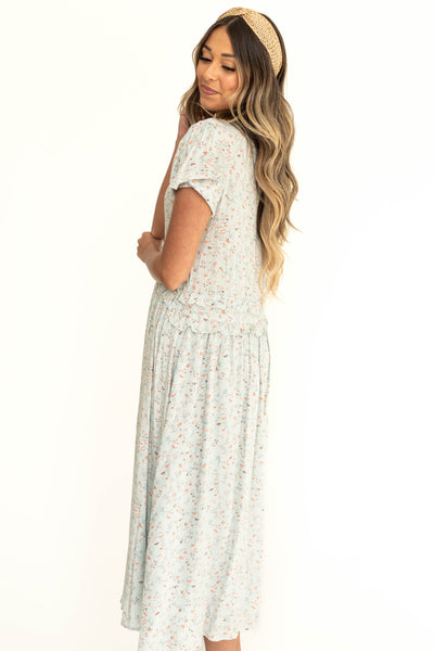 Side view of a light seafoam floral dress with short sleeves.