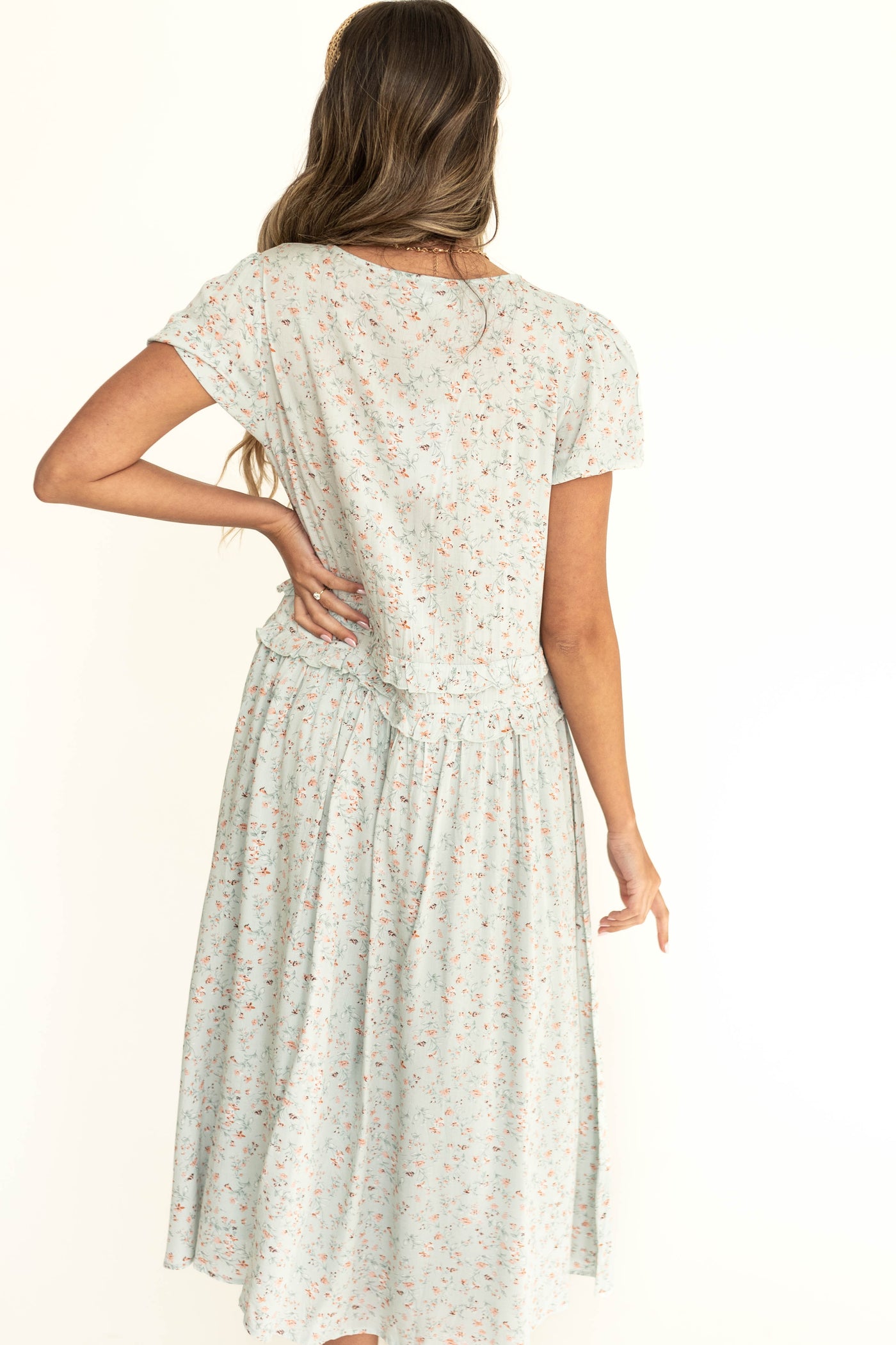 Back view of a short sleeve seafoam dress with a small floral print.