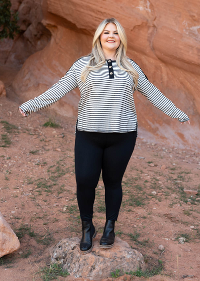 Plus size black striped top with long sleeves and buttons at the neck