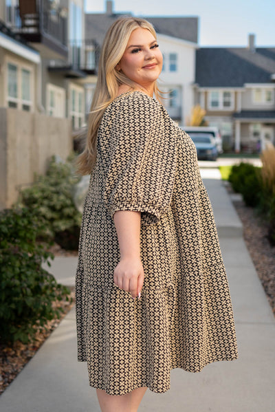 Side view of a plus size black pattern tiered dress
