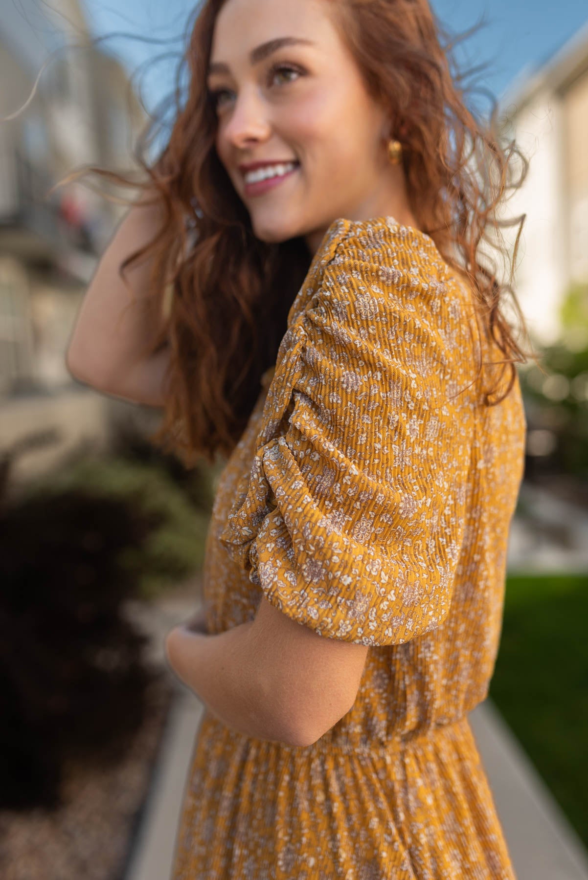 Close up of the sleeves that is gathered on a mustard dress 