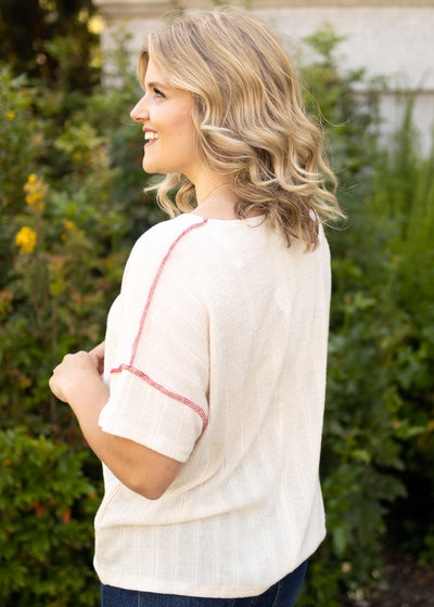 Side view of a short sleeve cream top