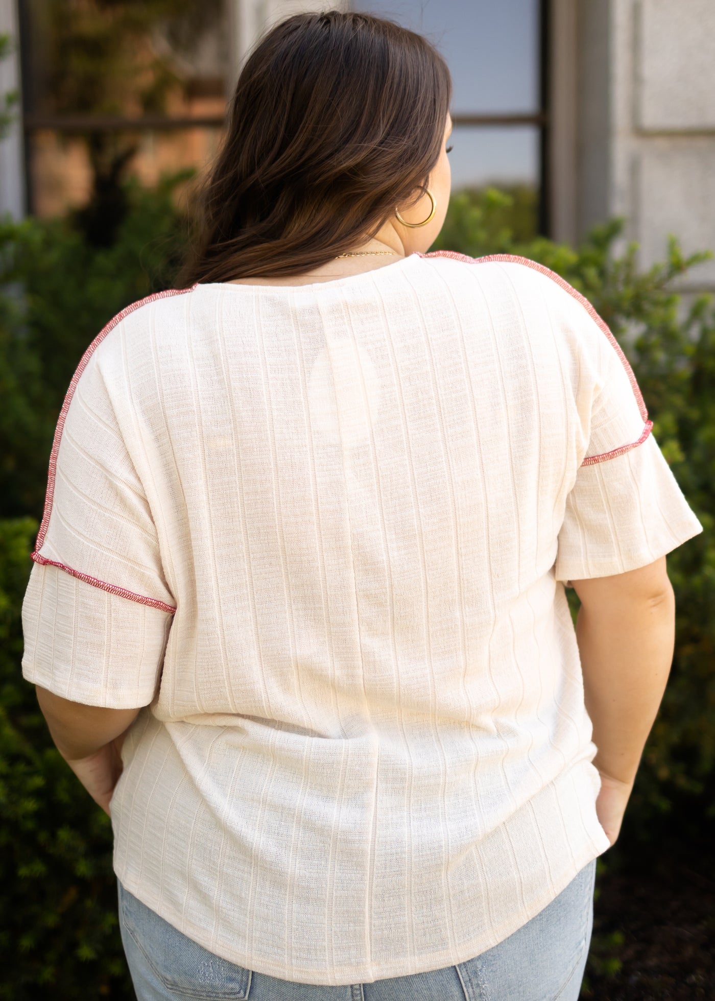 Back view of a short sleeve cream top with a v-neck