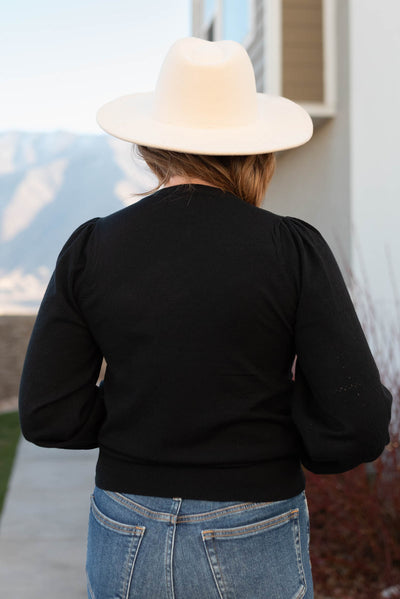 Back view of a black puff sleeve sweater