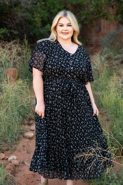 Plus size black floral dress with buttons on the bodice and a v-neck