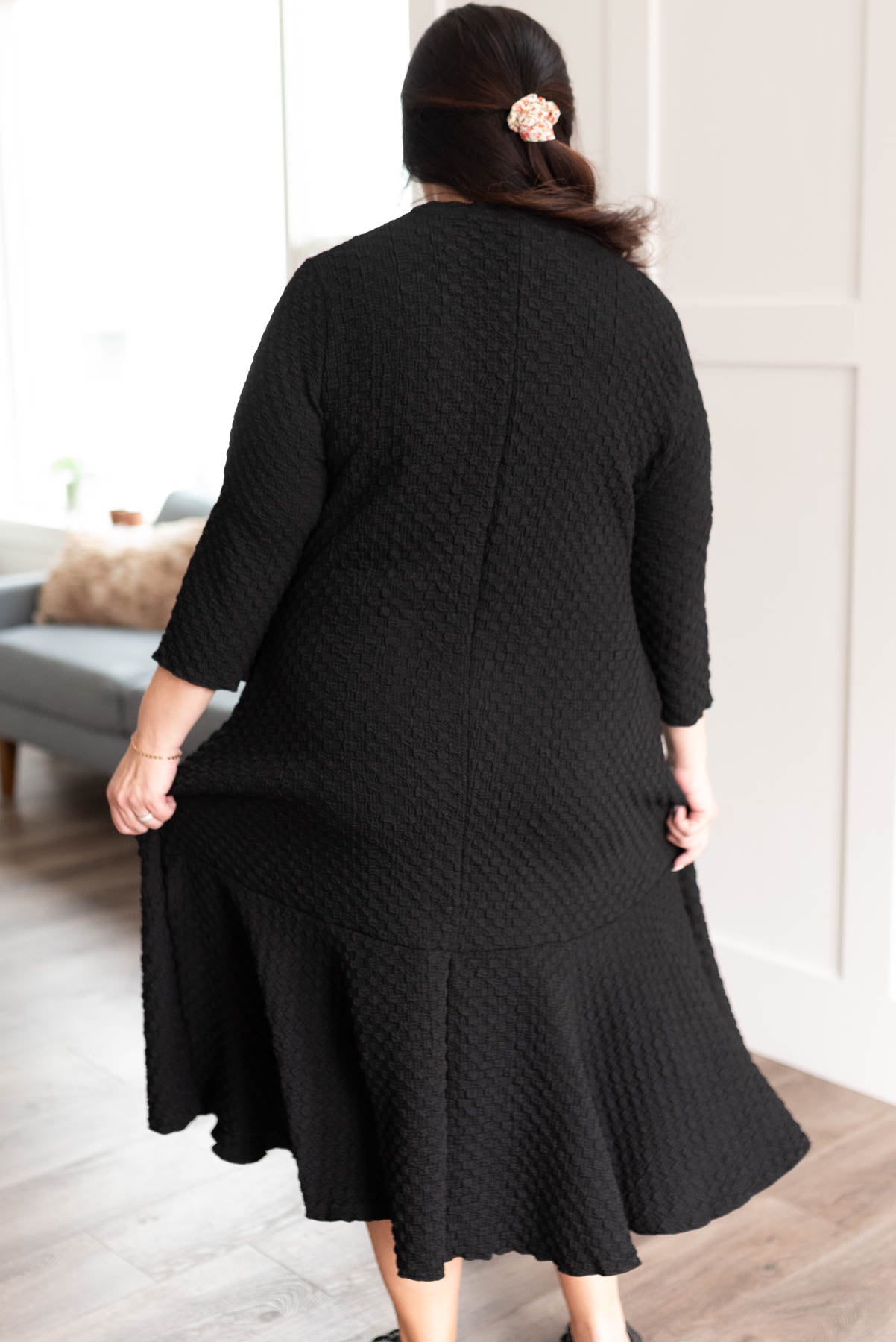 Back view of the plus size black textured ruffle hem dress