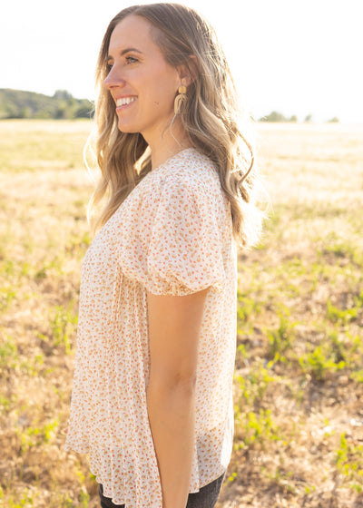 Side view of an ivory floral top
