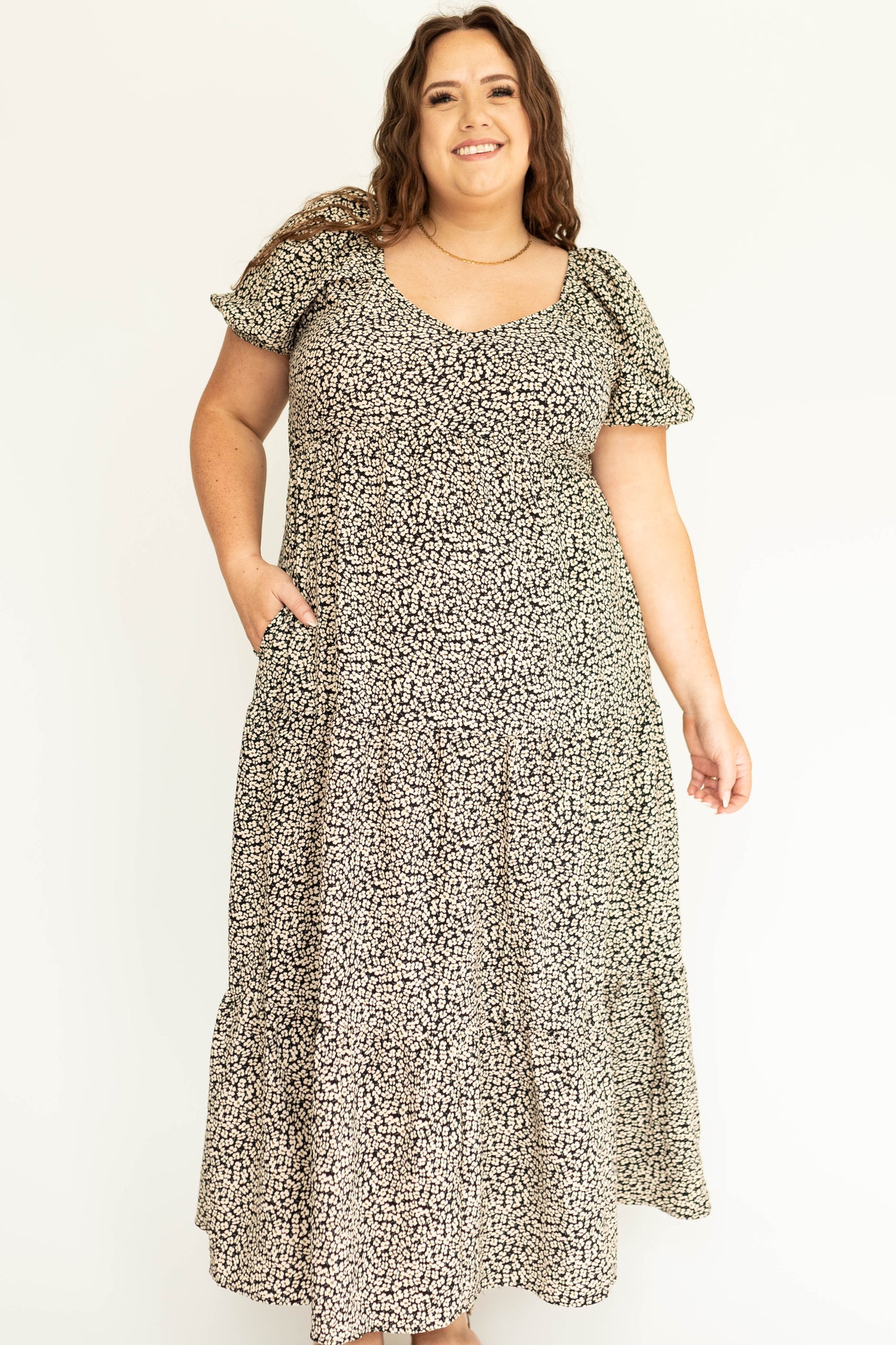 Front view of a plus size black floral dress with full sleeves