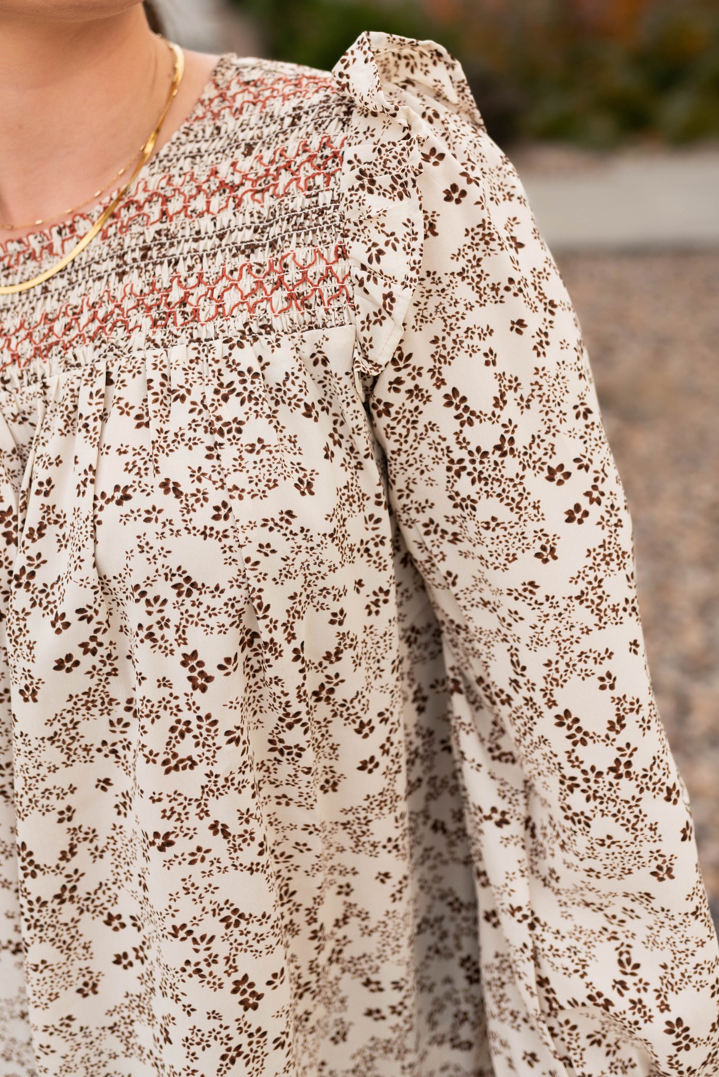 Taupe pattern blouse with embroidery stitching at the neck