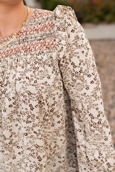 Taupe pattern blouse with embroidery stitching at the neck