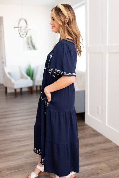 Side view of a navy embroidered dress