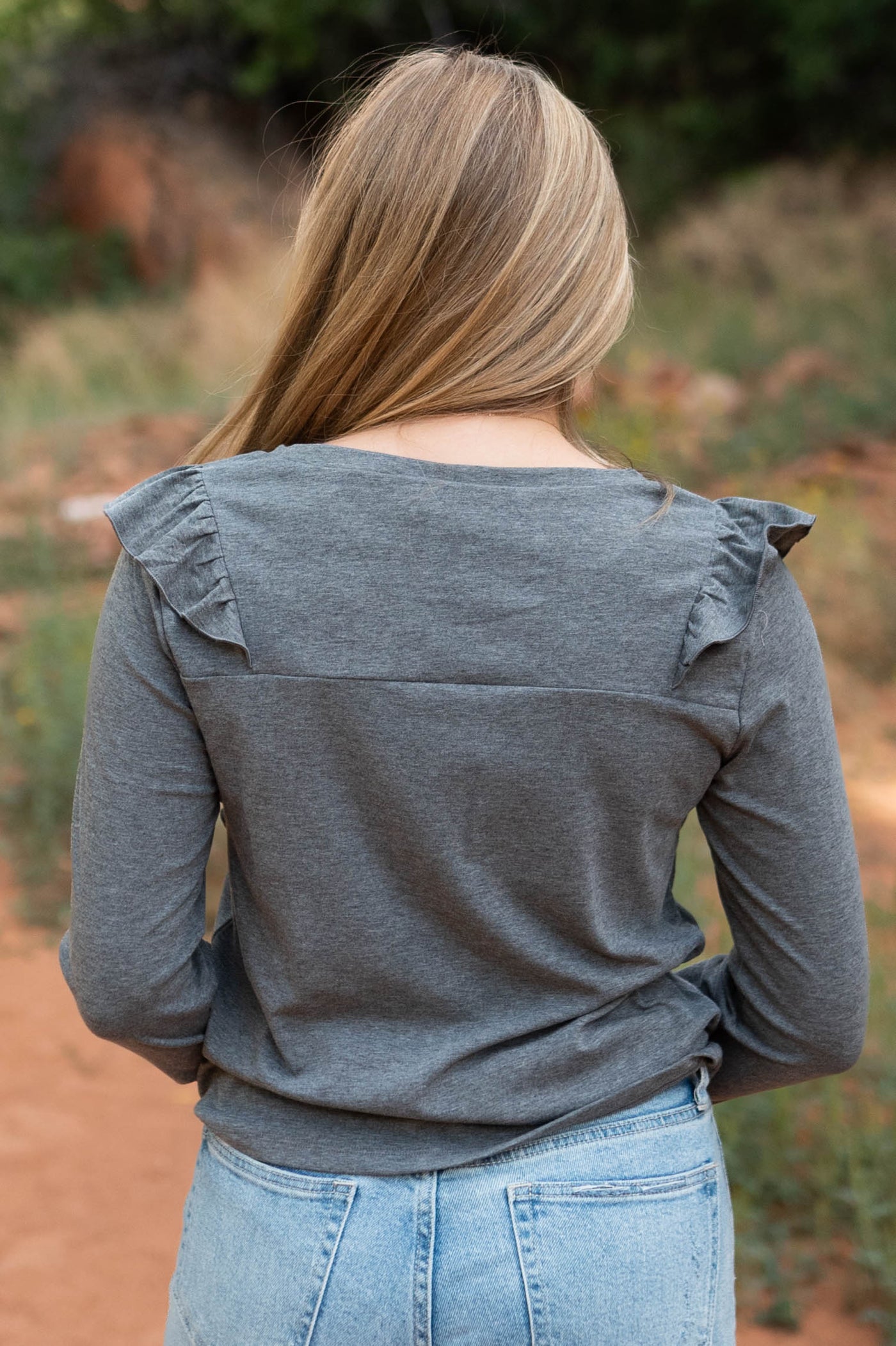 Back view of a charcoal top with ruffles on the shoulders