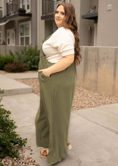 Side view of a plus size olive jumpsuit