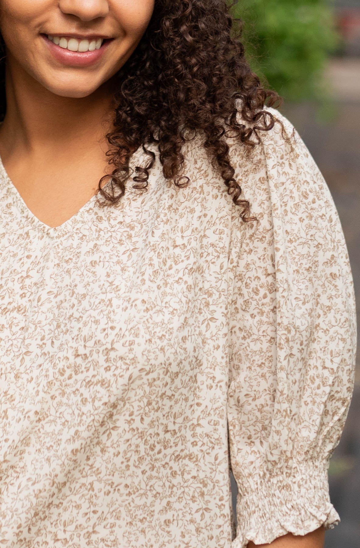 Close up view of the fabric on the taupe floral print top