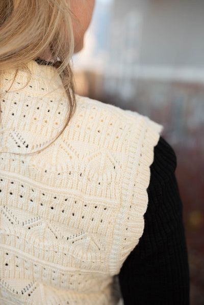 Close up of the sweater pattern on a ivory knit sweater vest