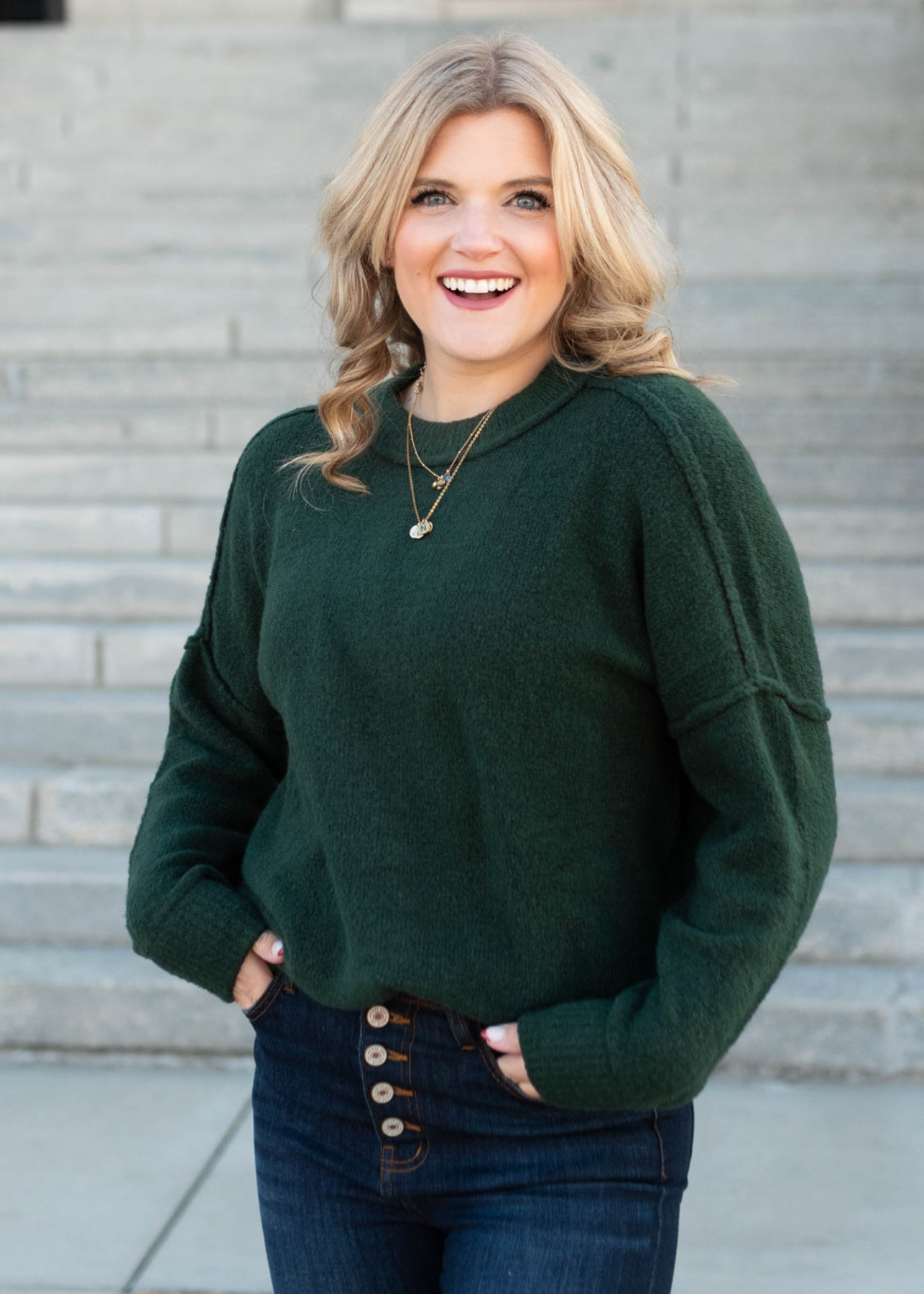 Front view of the hunter green knit pullover with a drop shoulder