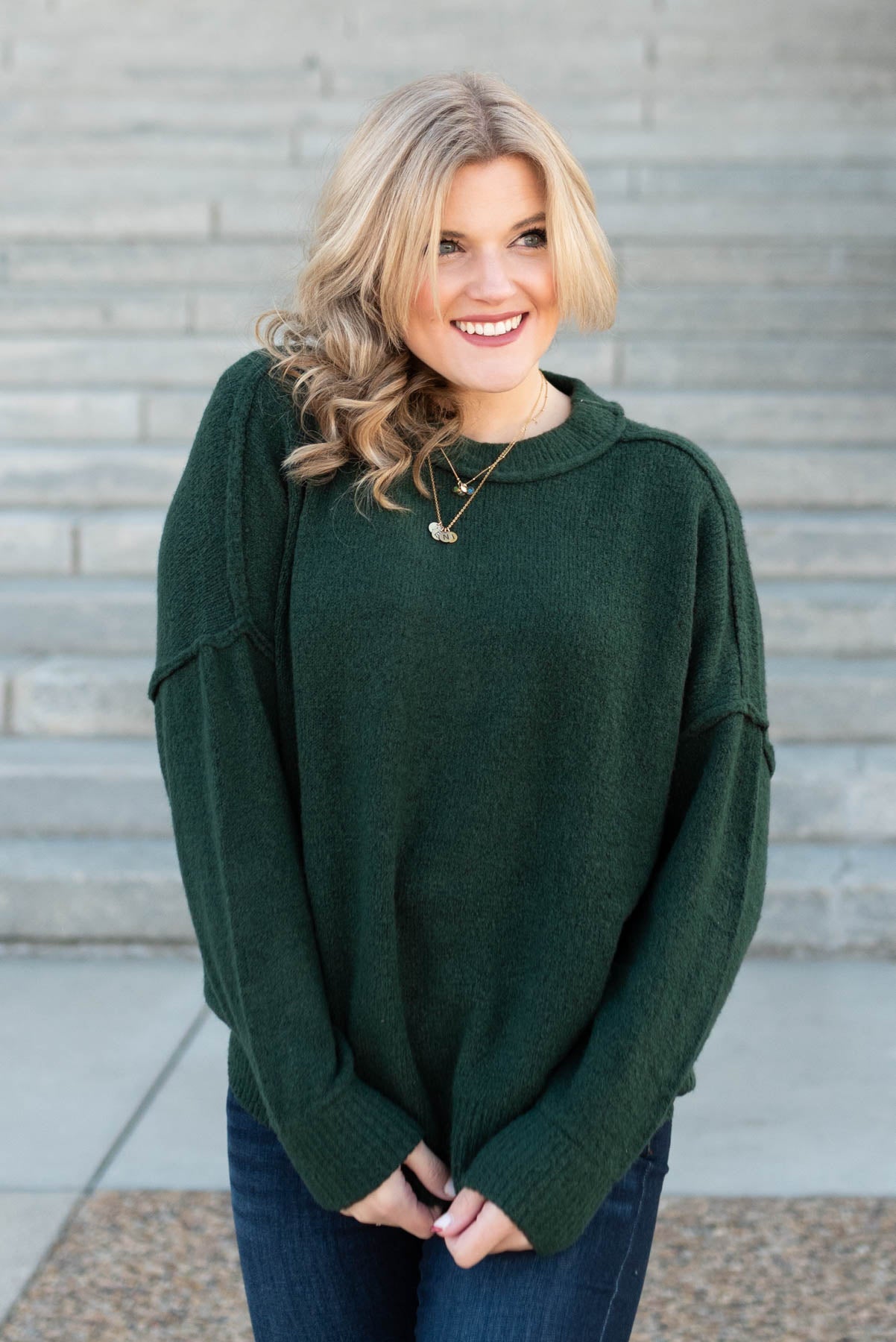 Long sleeve hunter green knit pullover with outside stitching