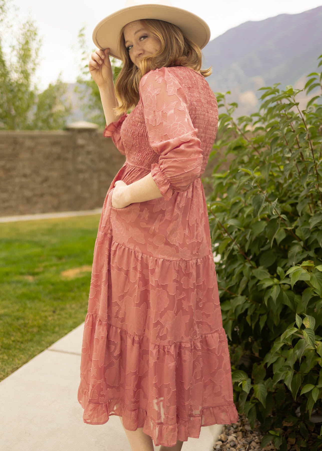 Side view of a dusty rose dress with pockets