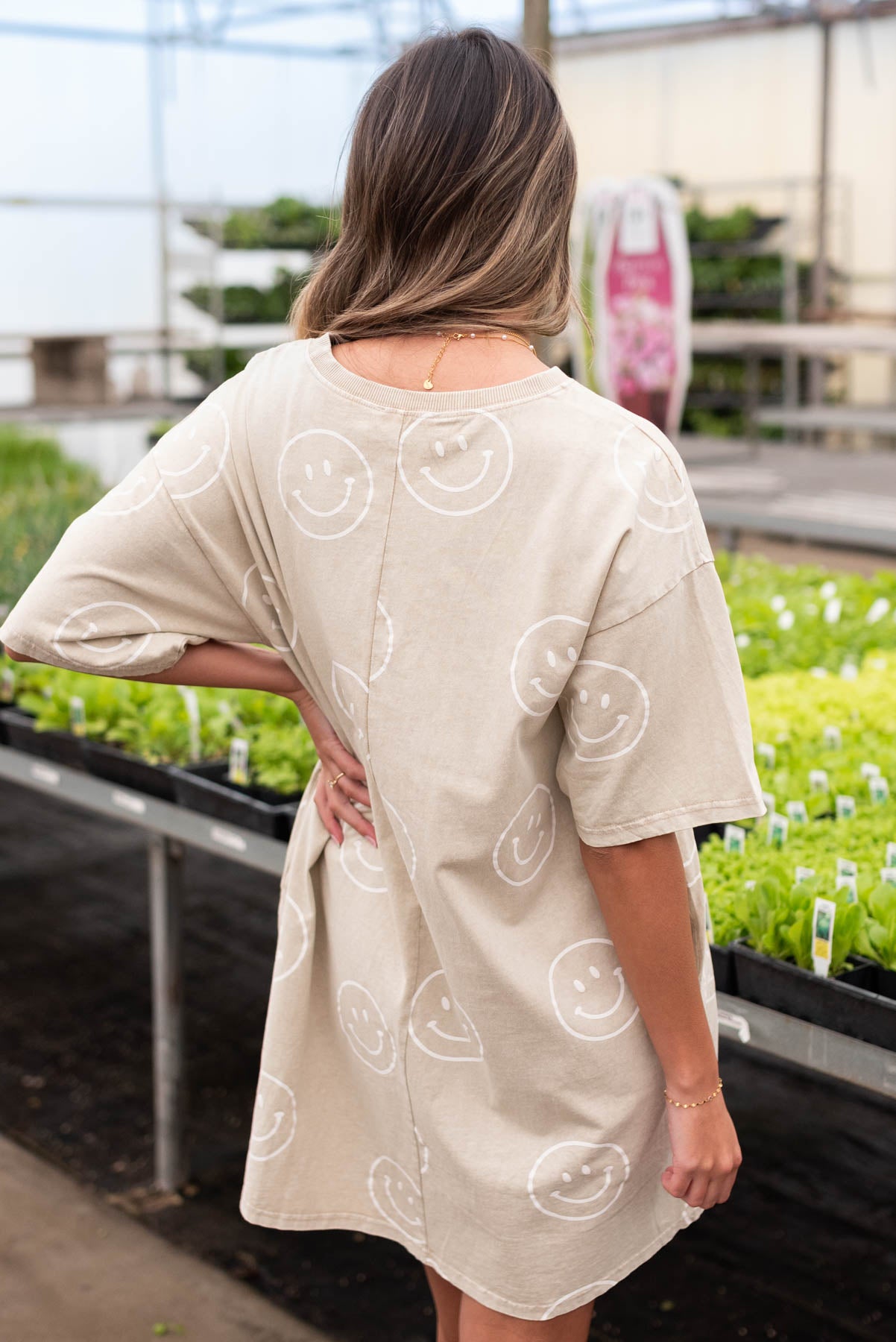Back view of the khaki tunic dress with white smiley faces