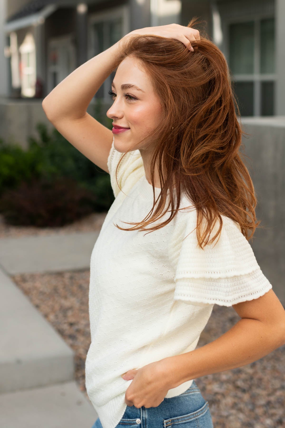 Side view of a ivory top with ruffle sleeves