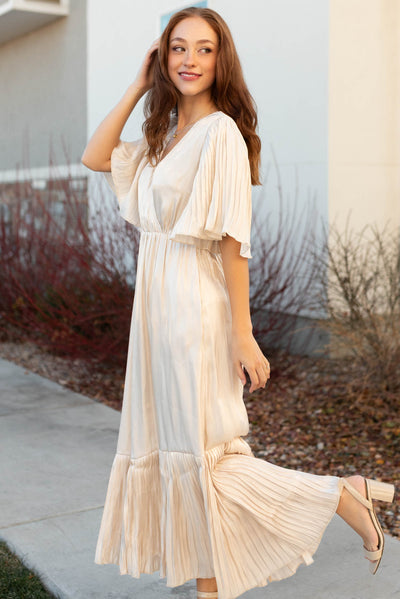 Side view of a cream pleated wrap dress