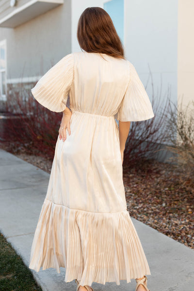 Back view of a cream pleated wrap dress